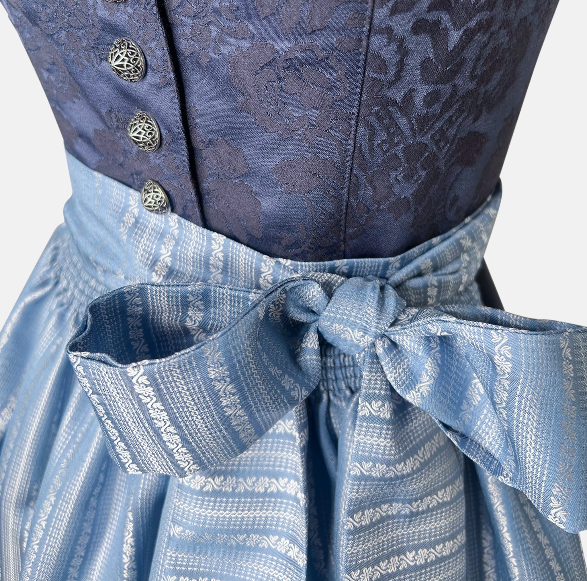 Apple of my Eye blends timeless tradition with contemporary design. The deep blue jacquard bodice features an elegant floral pattern