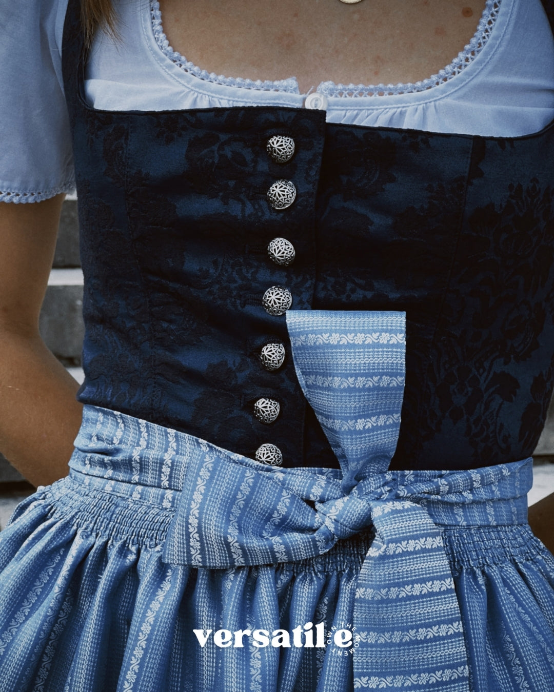 Rent Oktoberfest dirndl in Munich — ‘Apple of My Eye’ with blue jacquard bodice, square neck, silver closures, and sky-blue satin apron accented with woven pattern.