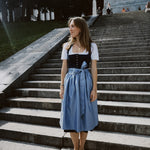 Oktoberfest-ready Dirndl ‘Apple of My Eye’ rental in Munich — navy floral jacquard bodice, delicate silver buttons, light blue striped skirt and apron.