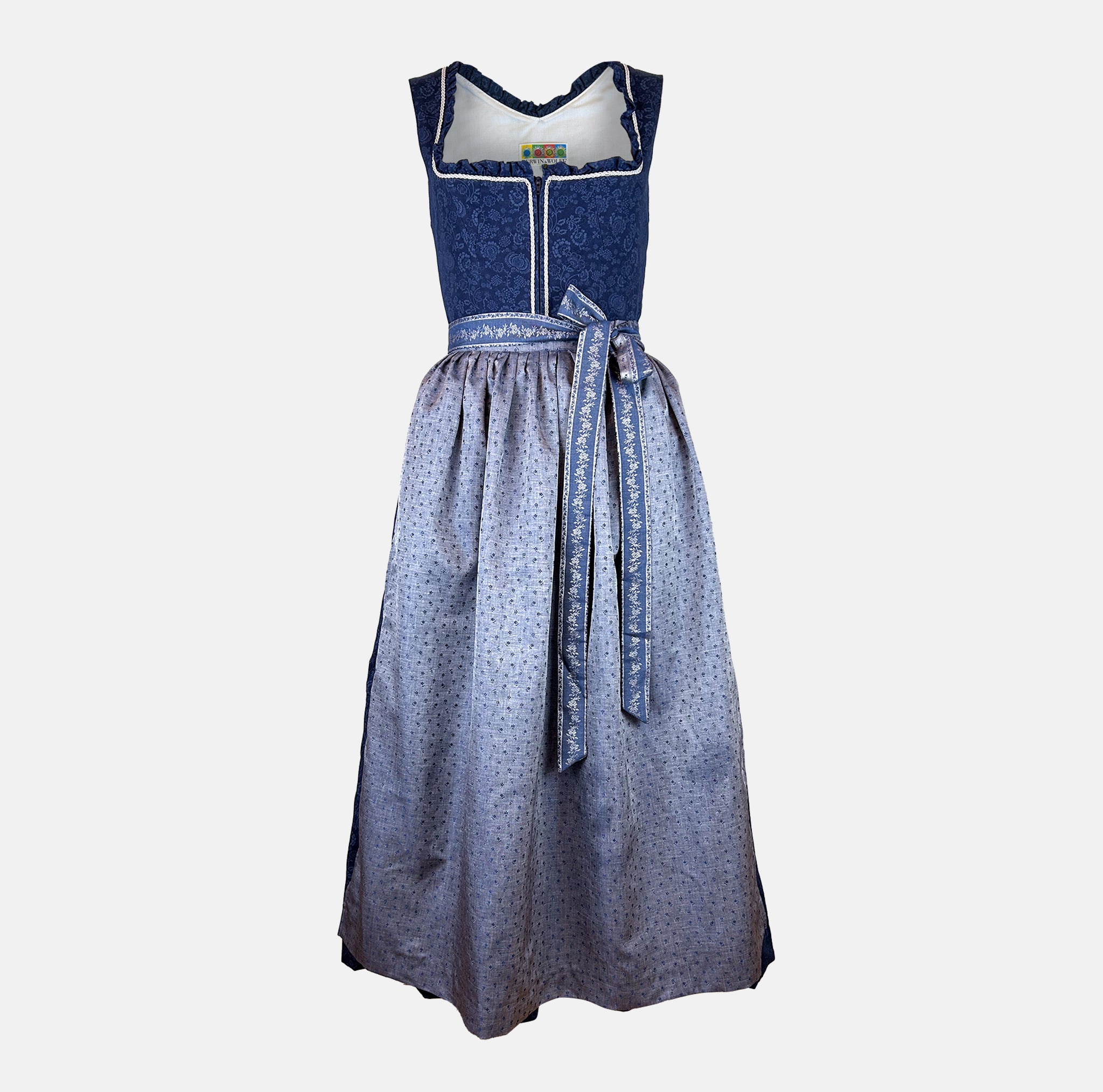 Berwin & Wolff dirndl rental via Versatile – navy floral jacquard bodice with white trim and light blue embroidered apron, ankle‑length Oktoberfest dress