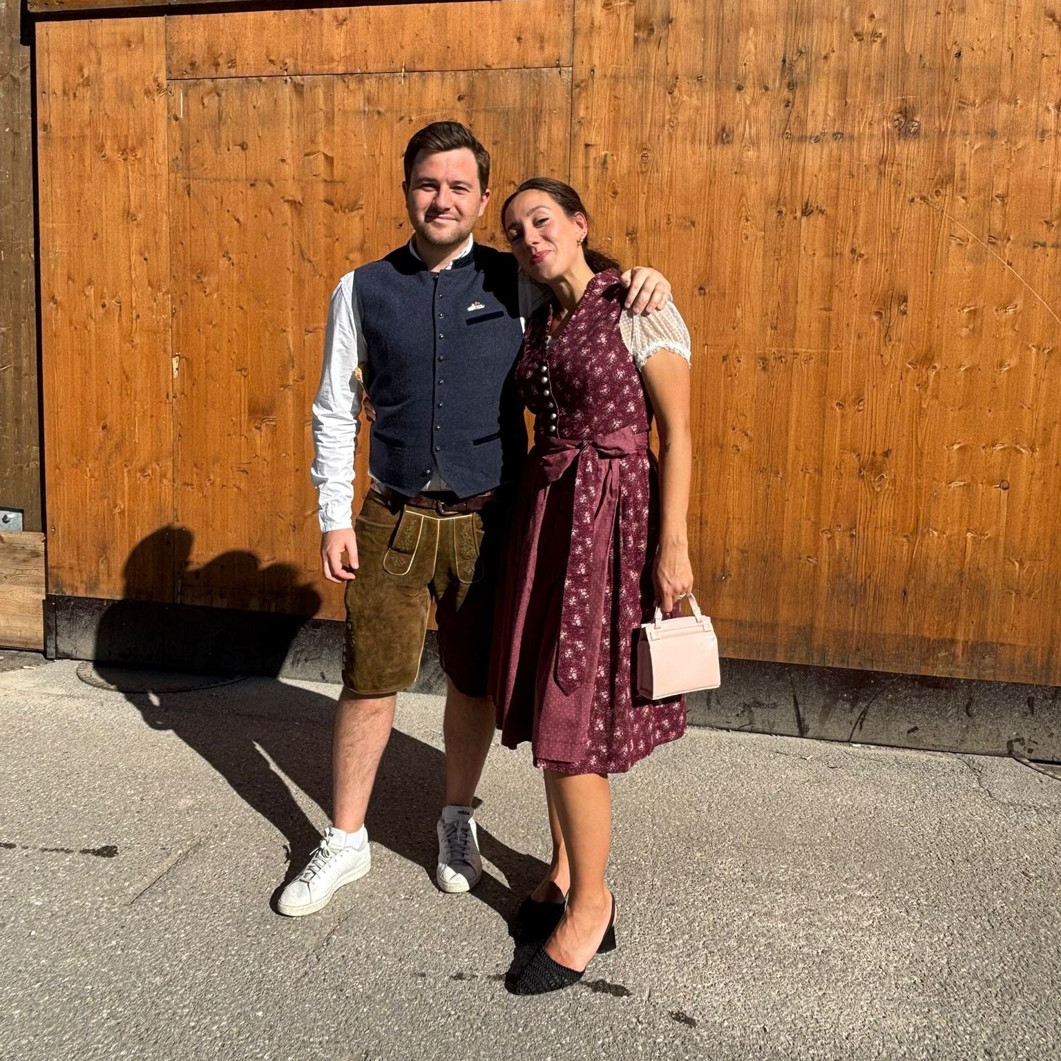 Oktoberfest Couple wearing Dirndl and Lederhosen. Burgundy Bewin & Wolf Dirndl ready to rent for Oktoberfest on Versatile OTM 
