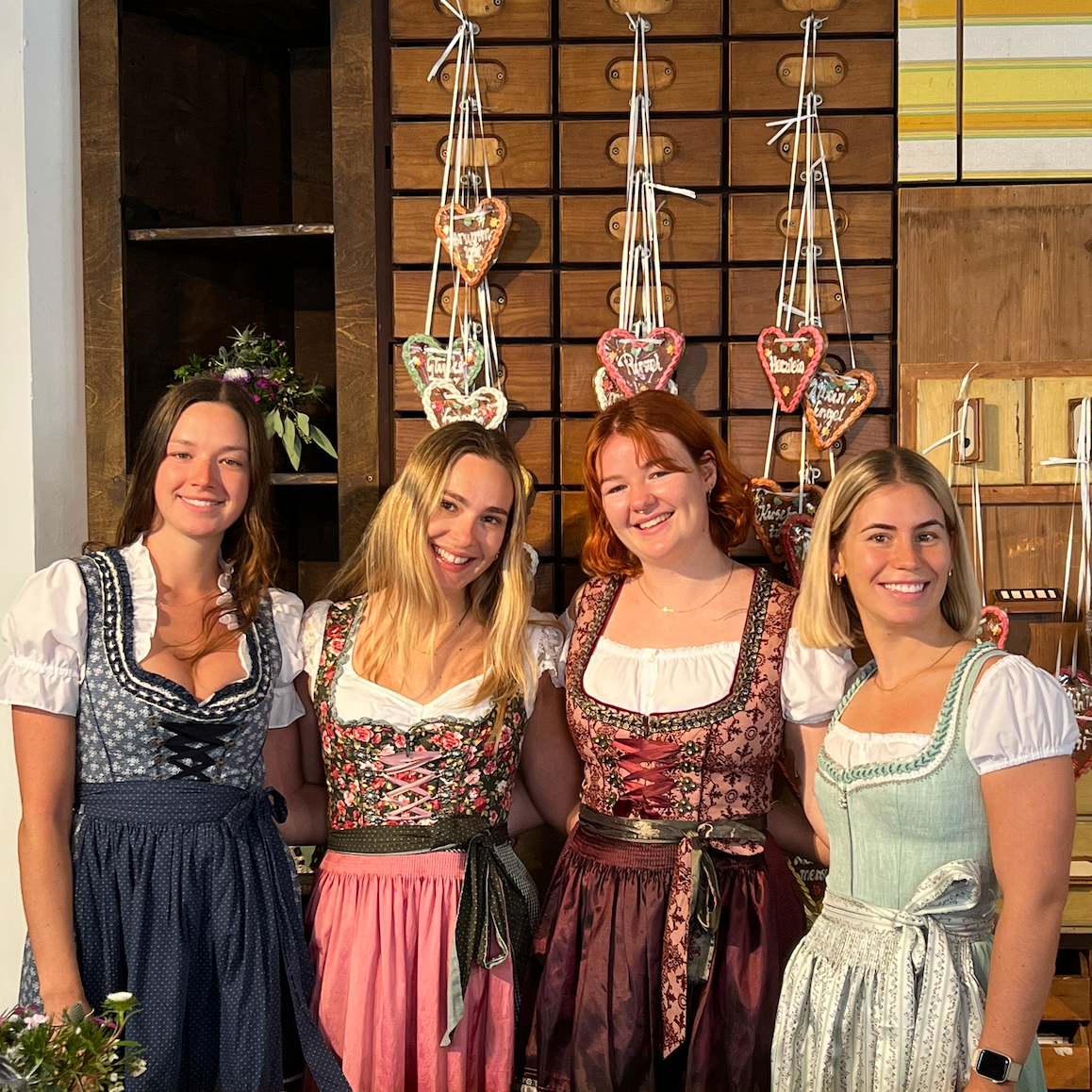 Four women wearing traditional German Dirndl dresses one bestseller Dirndl Krueger Dirndl. Ready to rent on Versatile OTM for Oktoberfest 