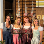 Four women wearing traditional German Dirndl dresses one bestseller Dirndl Krueger Dirndl. Ready to rent on Versatile OTM for Oktoberfest 