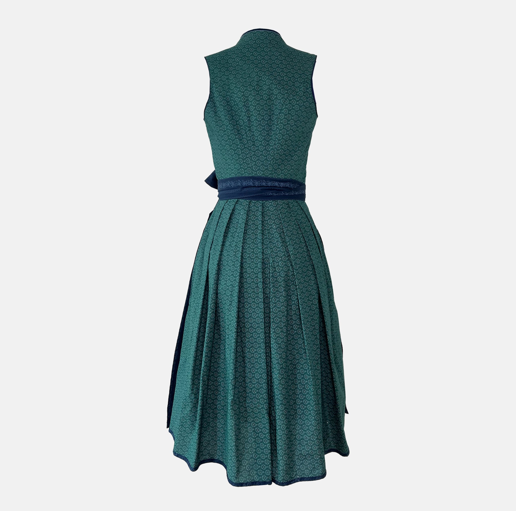 Dollar Tracht Dirndl with high-necked green bodice and deep blue patterned apron, available to rent at Versatile OTM.