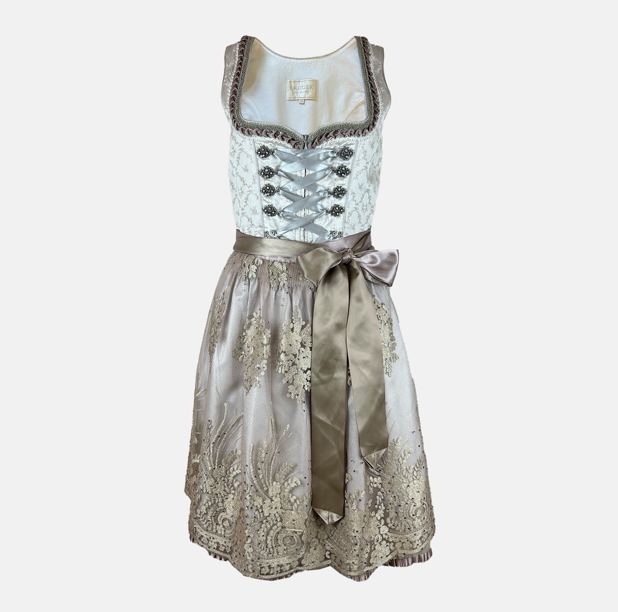 Close-up of a Krüger Dirndl featuring an ivory bodice with silver ribbon lacing and a gold embroidered apron. Skirt length 60cm. Elegant and luxurious.