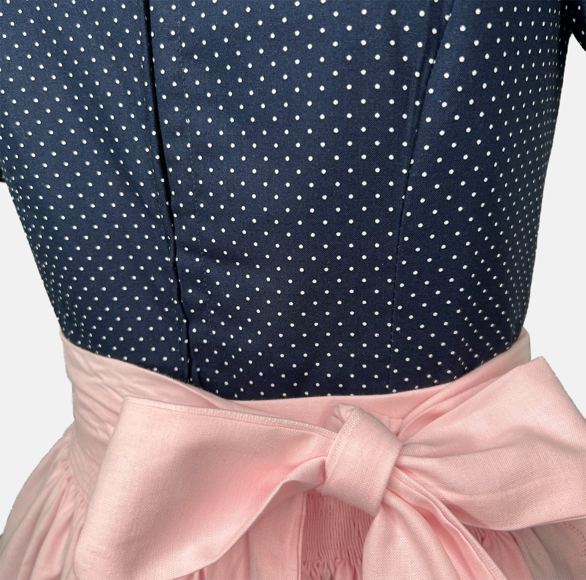 Elegant handmade Dirndl with navy top and soft pink apron—premium Bavarian dress rental from Versatile OTM in Munich