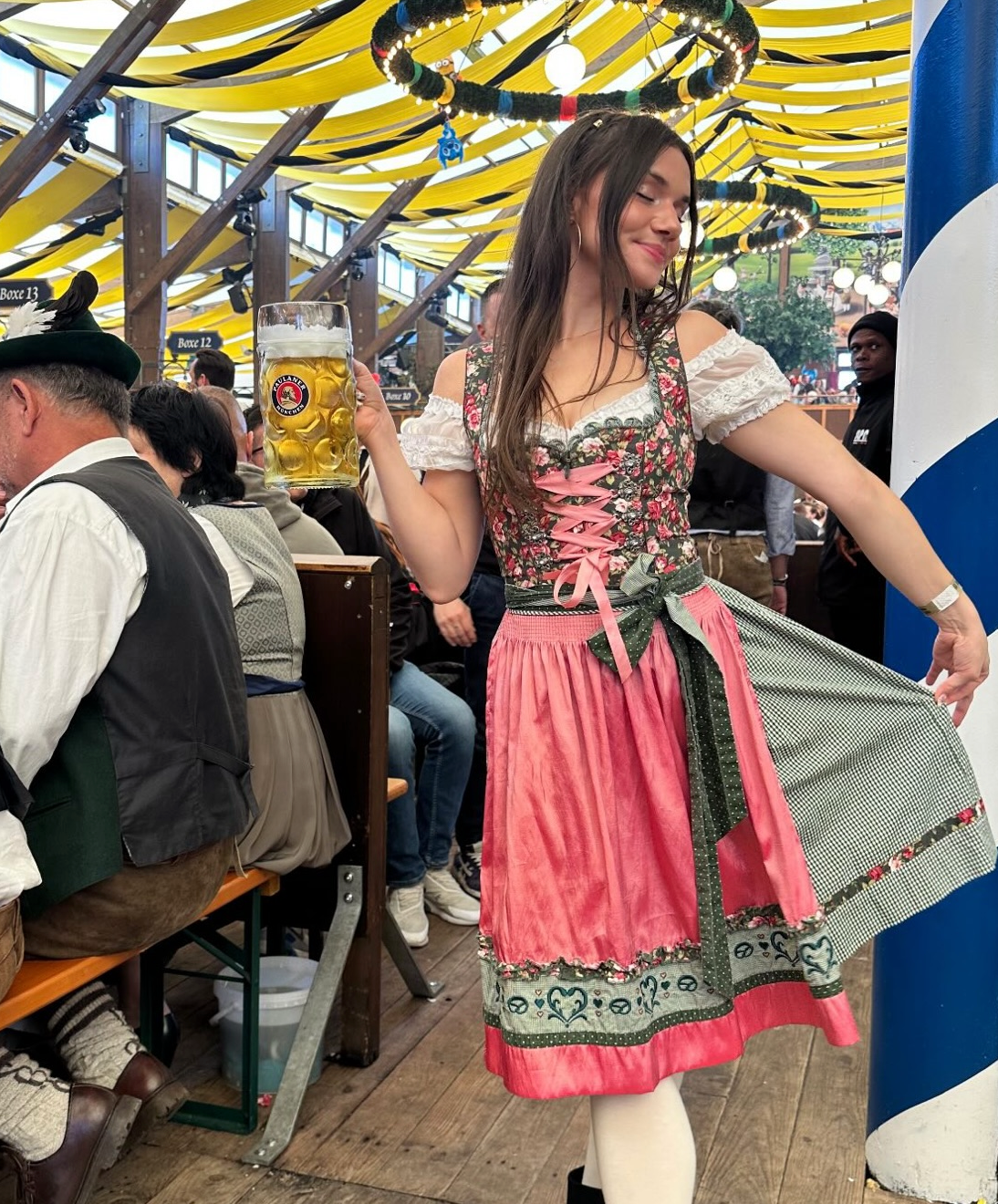 A woman posing in with traditional German Krueger Dirnld dresses at Oktoberfest. Dirndl ready to rent on Versatile OTM 