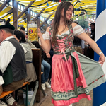 A woman posing in with traditional German Krueger Dirnld dresses at Oktoberfest. Dirndl ready to rent on Versatile OTM 