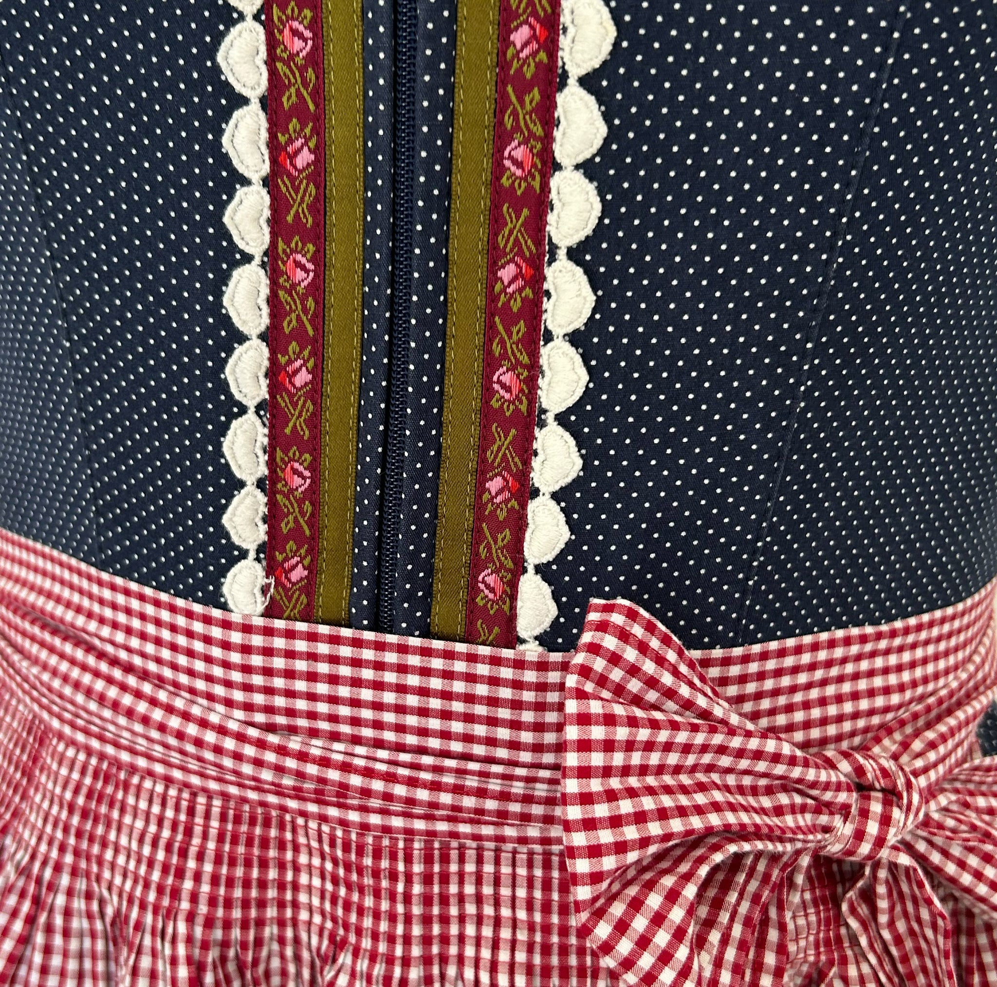 Versatile rental dirndl: traditional Bavarian dress with navy dotted bodice, red-white gingham apron and ribbon embroidery for Oktoberfest