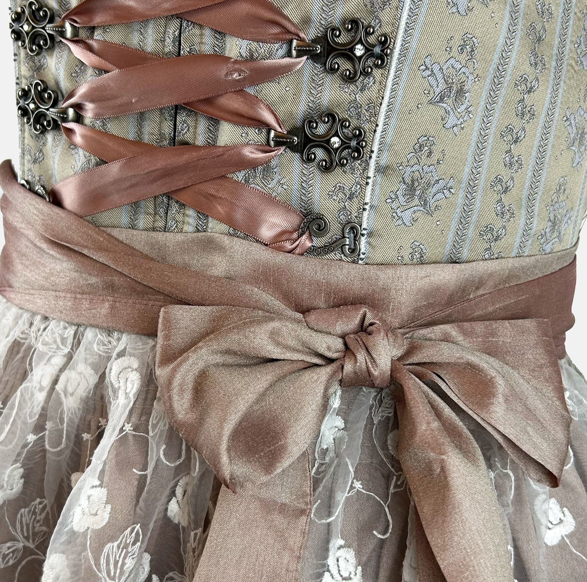 Krüger dirndl featuring an olive and taupe floral bodice, rose-gold ribbon lacing, and a mocha lace apron with white embroidered roses.
