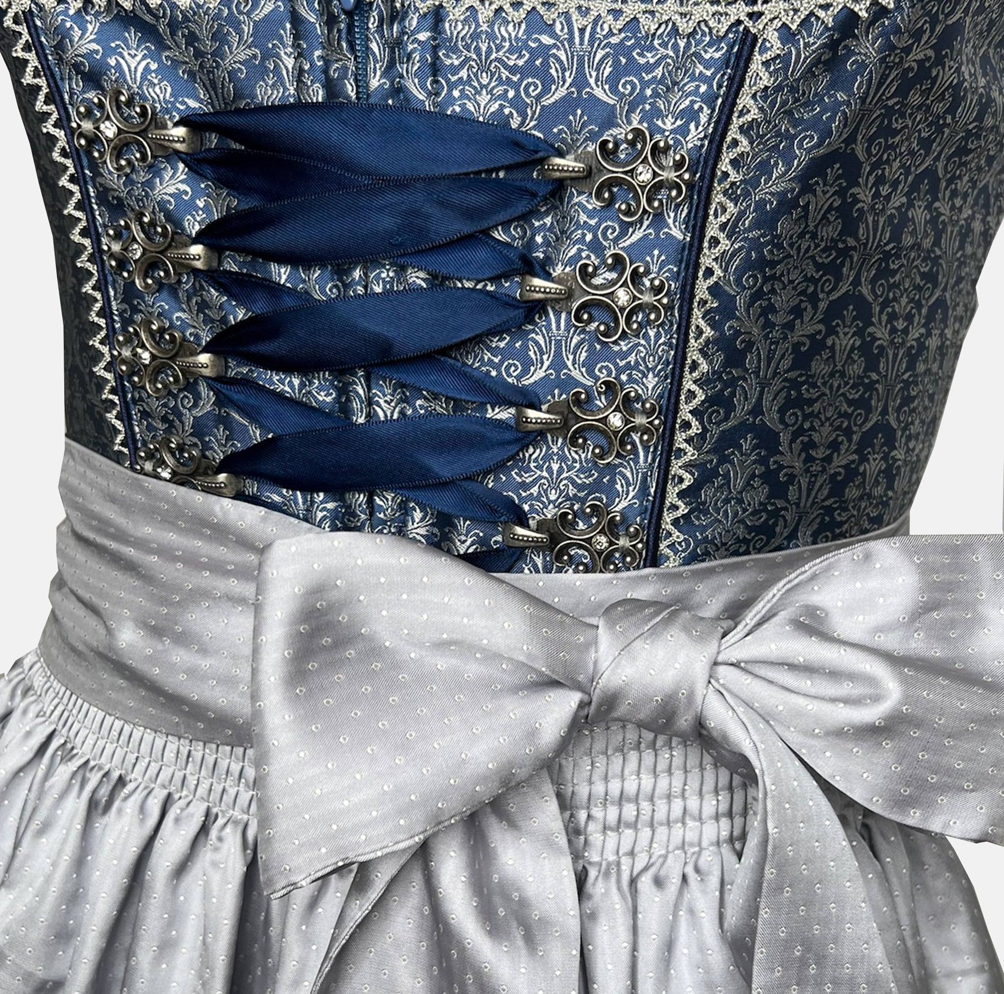 Elegant blue Krüger dirndl with silver apron, brocade bodice, and decorative lace details – available for rent at Versatile.