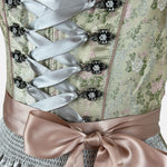 Pastel green Krüger Dirndl with satin ribbon and floral detailing – a refined and trendy option for Oktoberfest or chic celebrations.