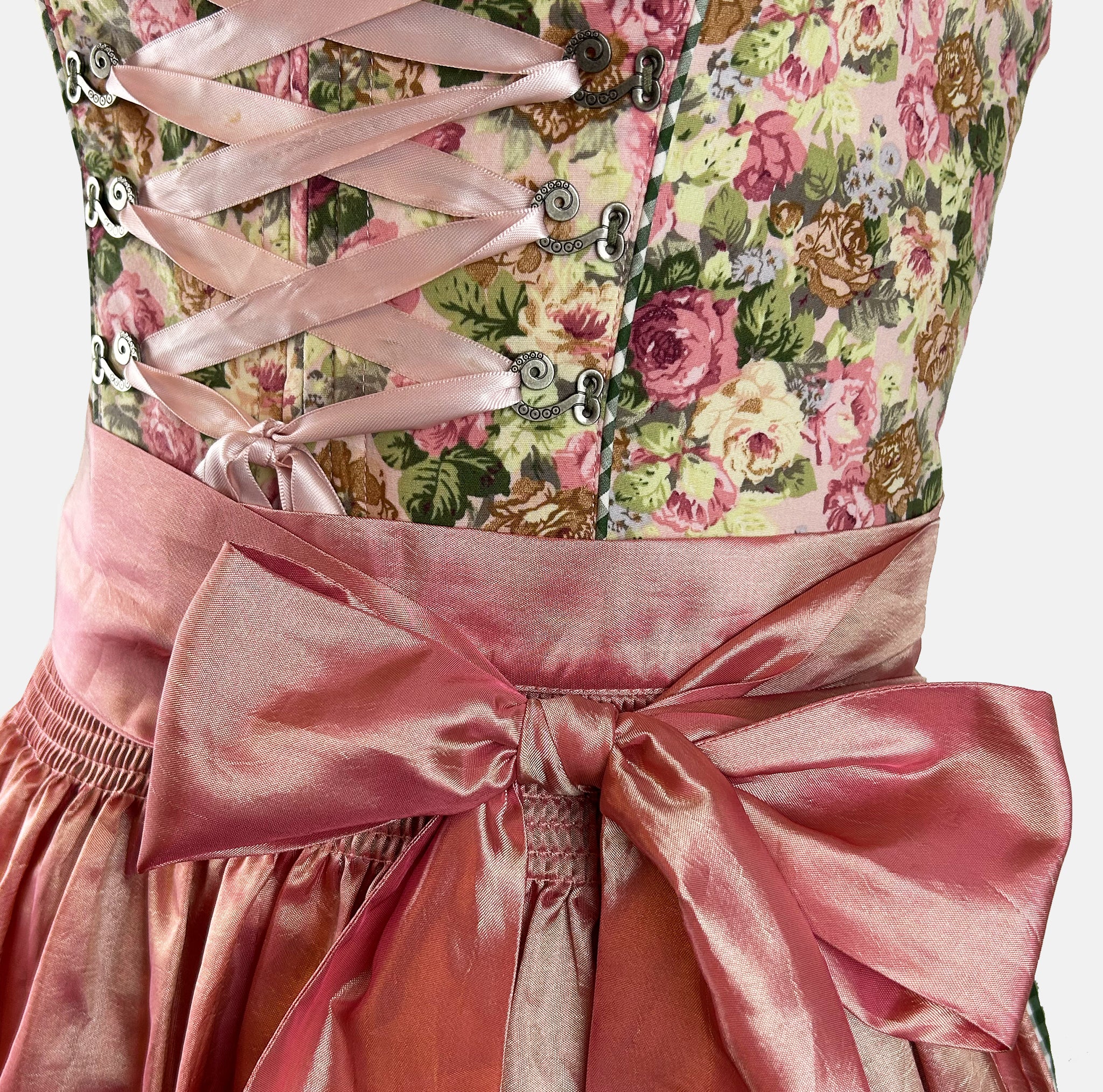 Rose-gold dirndl with floral bodice and satin apron, available for Oktoberfest rental in Munich