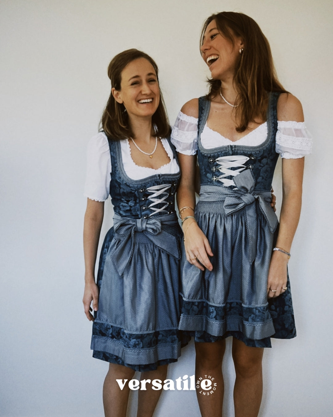 Krüger Bavarian dirndl ZAKIA with teal jacquard bodice, silver corset hooks, lace trim, and embroidered sheer apron—Oktoberfest rental in Munich.