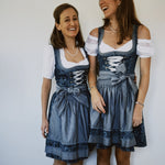 Krüger Bavarian dirndl ZAKIA with teal jacquard bodice, silver corset hooks, lace trim, and embroidered sheer apron—Oktoberfest rental in Munich.