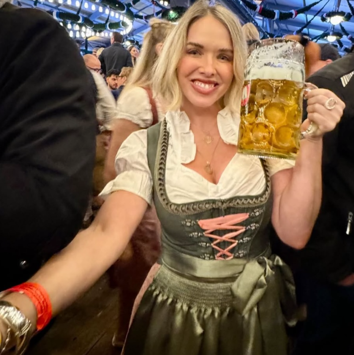 A woman in a traditional German dirndl rented on Versatile OTM. Krüger Dirndl Green rented for Oktoberfest 