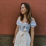 Krüger Maylin dirndl rental in Munich – soft blue heart-neck bodice with lace-up front, 70 cm midi skirt and delicate lace apron—perfect for Oktoberfest.