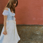Rent Krüger Dirndl Maylin in Munich: elegant blue midi dress with lace apron, front zipper, side pockets, and flattering fit—Oktoberfest ready.