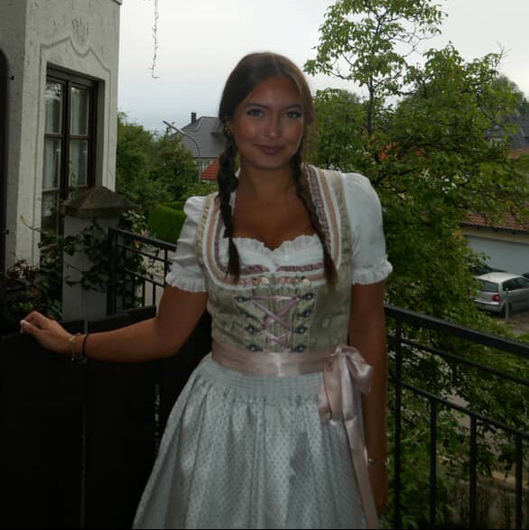 Girl wearing the Krueger Dirndl Ida rented for Oktoberfest. Traditional German Dirndl ready to rent on Versatile OTM 