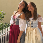 A women wearing a rented Krüger Dirndl from Versatile OTM. Traditional German Oktoberfest Dirndl together with a friend wearing a Dirndl