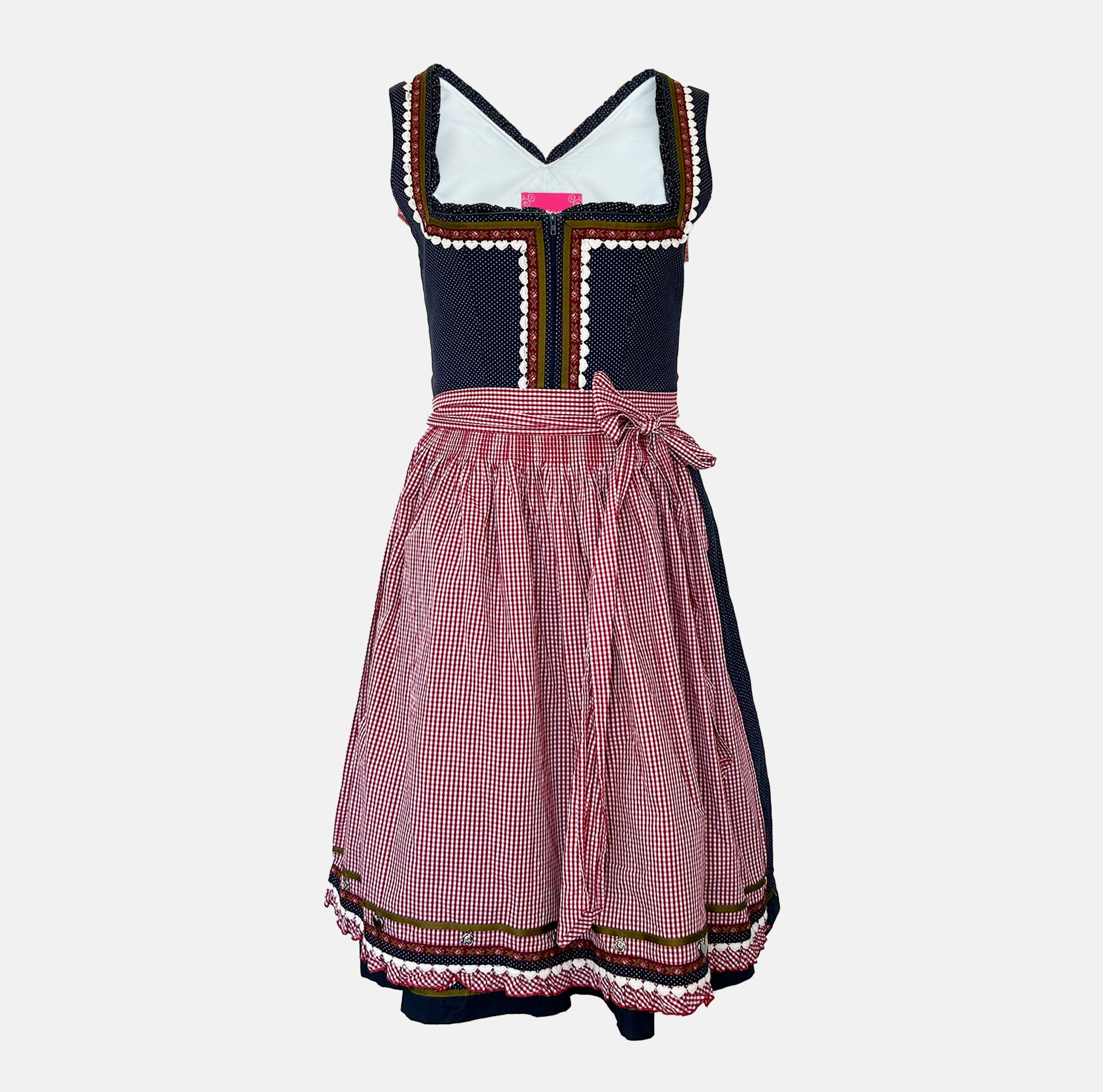 Traditional dirndl rental via Versatile, navy bodice with dotted fabric, red gingham apron, embroidered hem; Bavarian Oktoberfest outfit