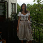 A woman wearing a traditional German Krüger Dirndl dress for Oktoberfest. Ready to rent on Versatile OTM 