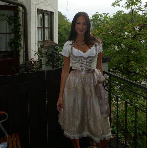 A woman wearing a traditional German Krüger Dirndl dress for Oktoberfest. Ready to rent on Versatile OTM 