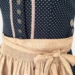 Marjo Bavarian rental dirndl with navy dotted button-front bodice and beige patterned apron, available at Versatile OTM in Munich.