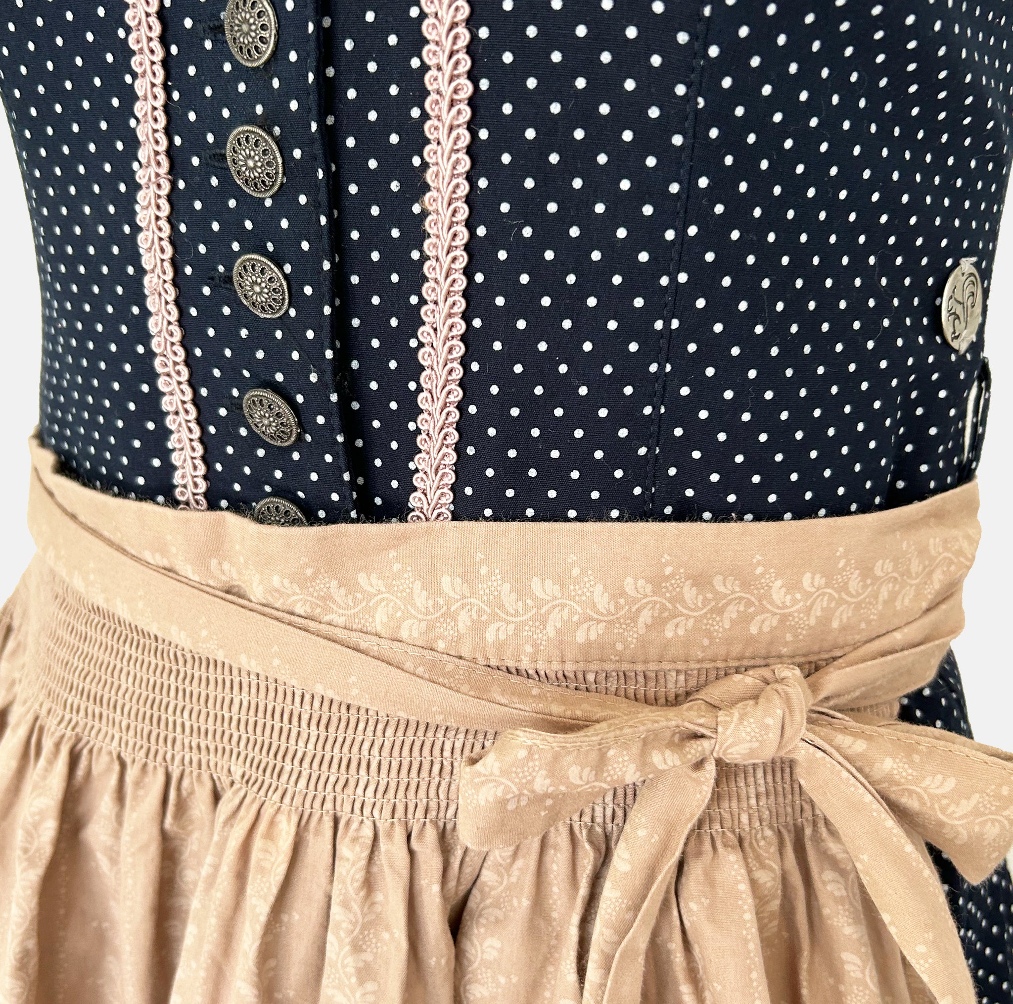 Marjo Bavarian rental dirndl with navy dotted button-front bodice and beige patterned apron, available at Versatile OTM in Munich.