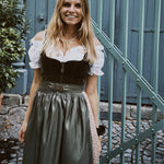 Rent a MarJo dirndl in Munich—olive velvet top, gold buckle, A-line skirt with beige pattern; perfect for Oktoberfest celebrations.