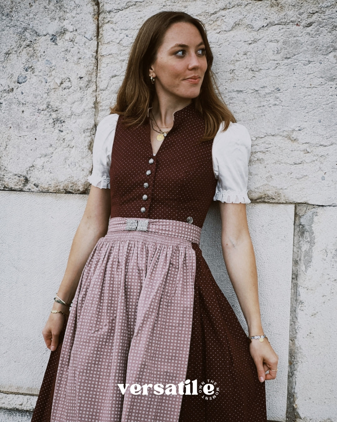 Elegant Marjo Bavarian dirndl rental with burgundy V-neck bodice, button-front detail, and flowing beige skirt — ideal for Oktoberfest in Munich.