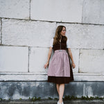 Marjo rental dirndl in Munich — deep burgundy jacquard bodice with V-neck and silver-tone buttons, beige embossed skirt; Oktoberfest dress hire.