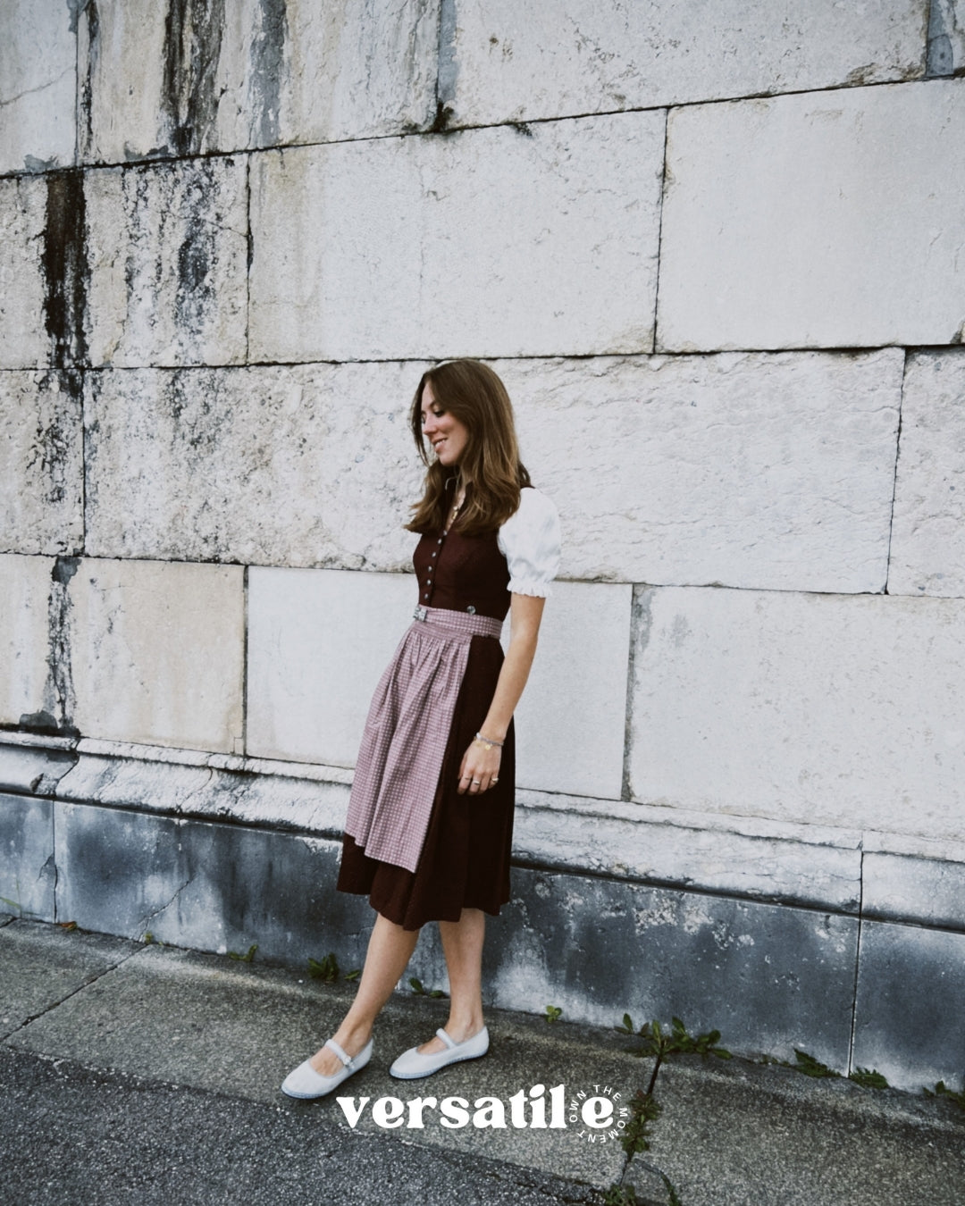 Munich dirndl rental — Marjo deep burgundy V-neck with silver buttons and beige textured skirt; perfect for Oktoberfest celebrations.