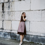 Rent the Marjo Burgundy Dirndl in Munich — fitted sleeveless design with silver buttons, deep V-neck, and beige gathered skirt for Oktoberfest.