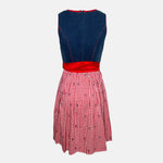 Cheeky red and navy dirndl with gingham bodice, lace-up detail, and red satin apron, available for rental at Versatile OTM, owned by Beer&Pretzel Tours