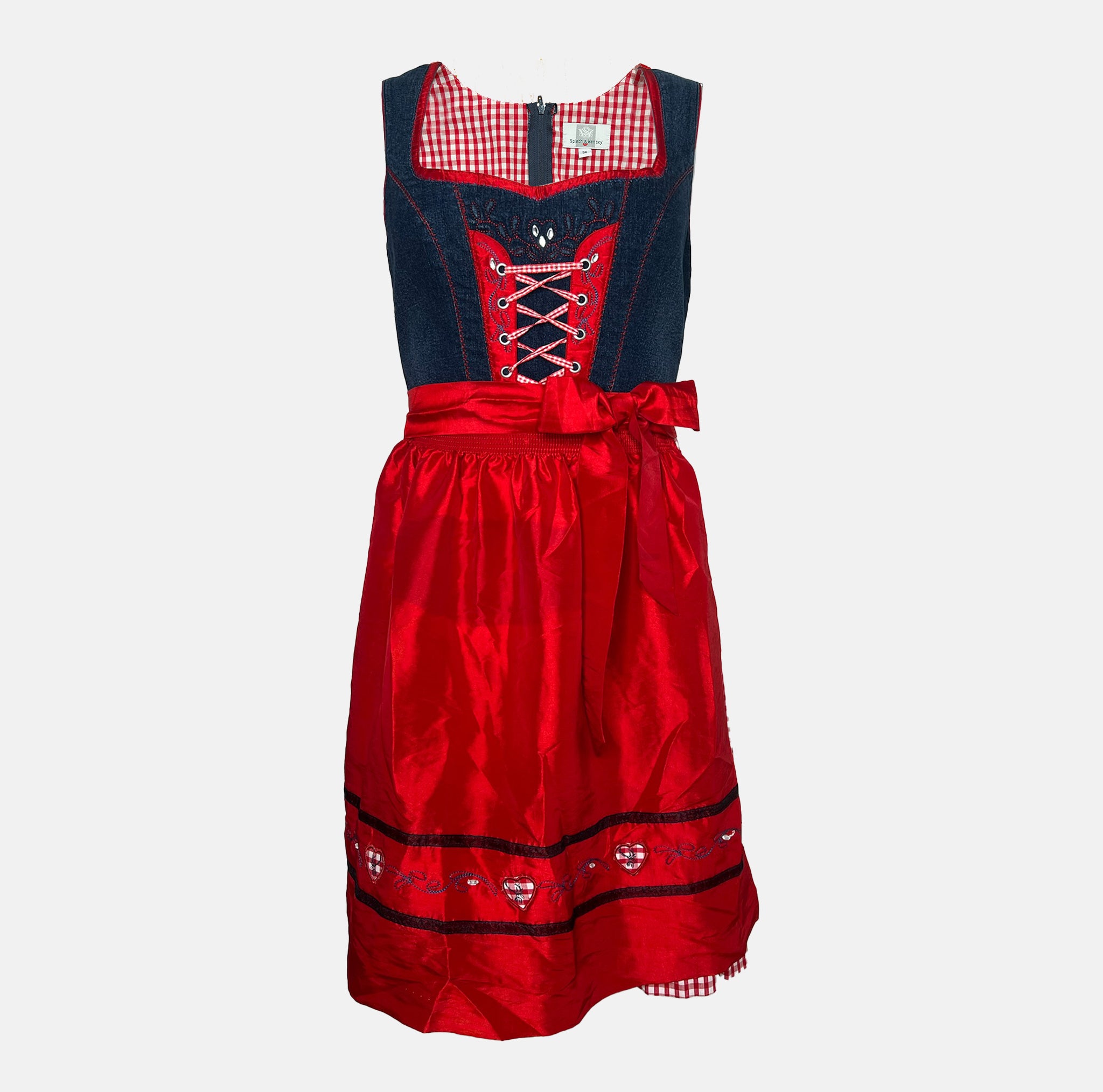 Cheeky red and navy dirndl with gingham bodice, lace-up detail, and red satin apron, available for rental at Versatile OTM, owned by Beer&Pretzel Tours