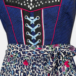 Cheeky dirndl with navy bodice, pink gingham trim, and leopard-print apron with floral accents, available for rental at Versatile OTM, owned by Beer&Pretzel Tours.