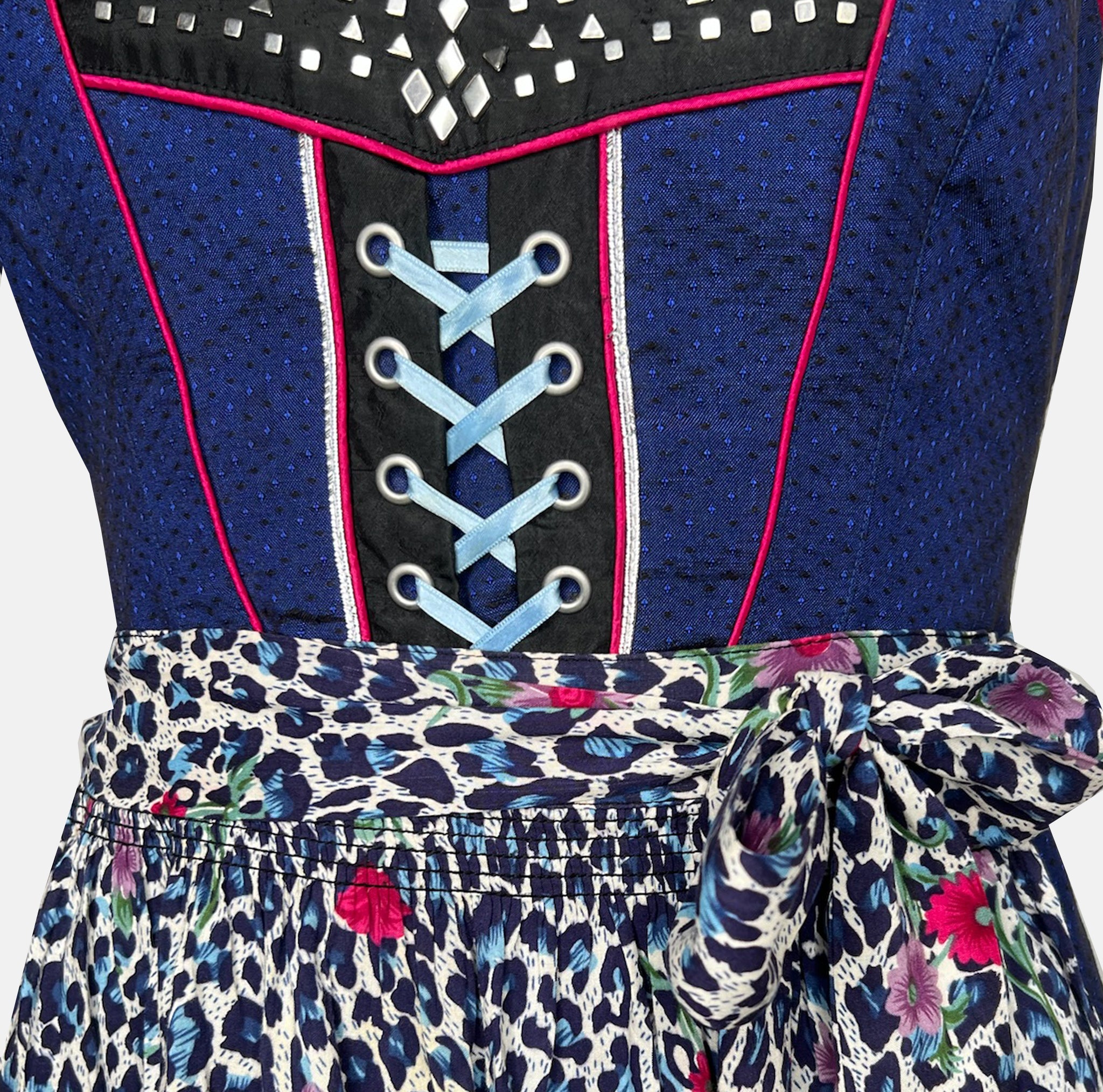 Cheeky dirndl with navy bodice, pink gingham trim, and leopard-print apron with floral accents, available for rental at Versatile OTM, owned by Beer&Pretzel Tours.