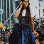Woman wearing a blue lace dress Dirndl Pia form the versatile collection with 'versatile' branding in an urban setting ready for Oktoberfest