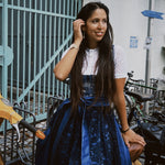 Woman wearing a blue lace dress Dirndl Pia form the versatile collection with 'versatile' branding in an urban setting ready for Oktoberfest