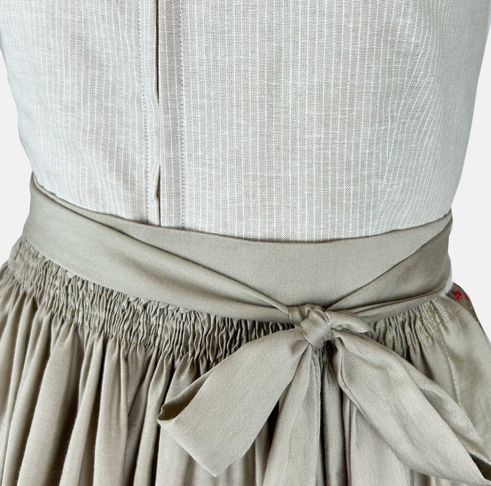 Handmade Versatile Collection Dirndl in light taupe with pleated neckline and flowing apron. Elegant, minimal, and made in Germany.