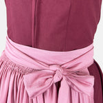 Exclusive Versatile Collection dirndl in berry with soft rose apron. Handmade in Germany, sustainable and fashion-forward. Rent a dirndl!