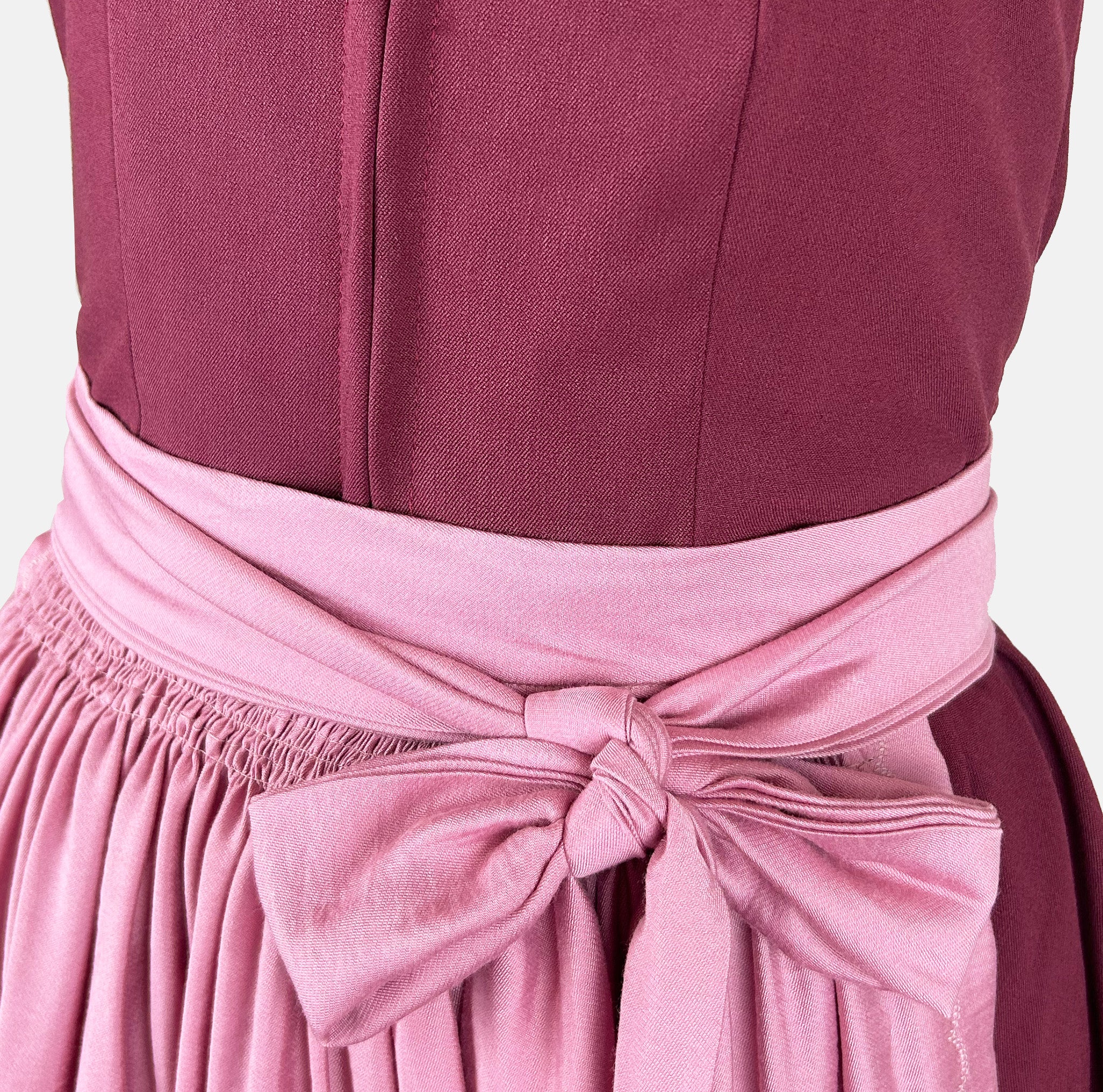 Exclusive Versatile Collection dirndl in berry with soft rose apron. Handmade in Germany, sustainable and fashion-forward. Rent a dirndl!