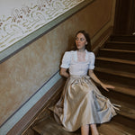 Handcrafted Munich rental dirndl Christine, light taupe textured bodice with pleated round neckline and flowing 70 cm skirt—ideal for Oktoberfest.