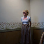 Minimalistic Christine Versatile Collection dirndl in light taupe with pleated neckline and A-line skirt – premium Oktoberfest rental in Munich.