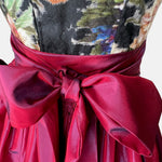 A traditional German Dirndl dress featuring a floral embroidered bodice and a deep red satin apron. 

Oktoberfest ready to rent our Versatile Collection Dirndl Celine