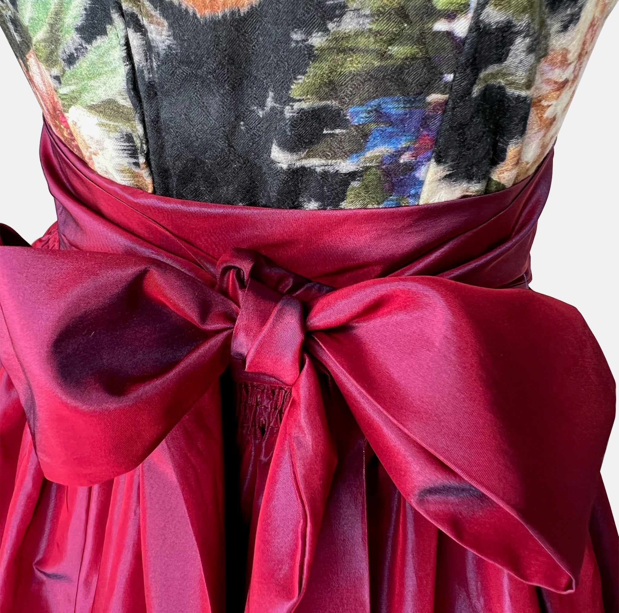 A traditional German Dirndl dress featuring a floral embroidered bodice and a deep red satin apron. 

Oktoberfest ready to rent our Versatile Collection Dirndl Celine