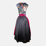 A traditional German Dirndl dress featuring a floral embroidered bodice and a deep red satin apron. 

Oktoberfest ready to rent our Versatile Collection Dirndl Celine