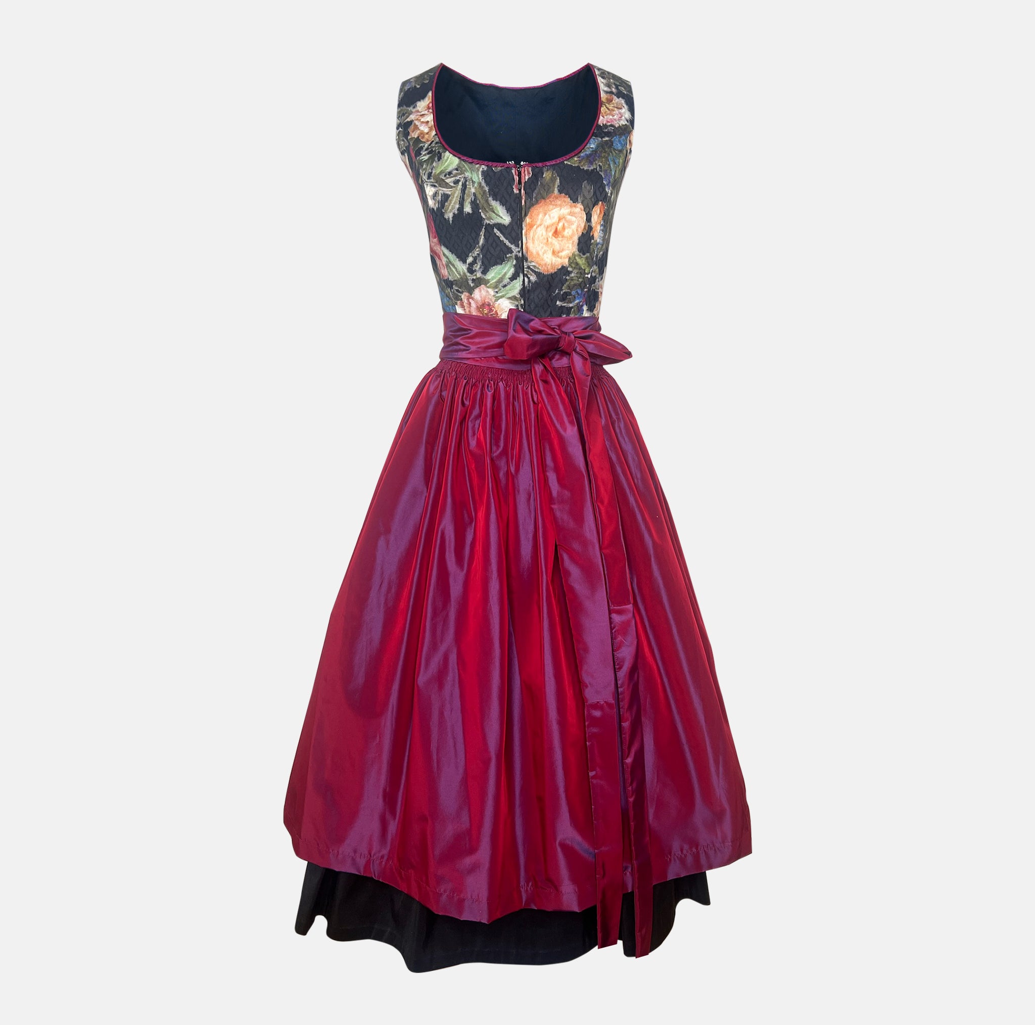 A traditional German Dirndl dress featuring a floral embroidered bodice and a deep red satin apron. 

Oktoberfest ready to rent our Versatile Collection Dirndl Celine