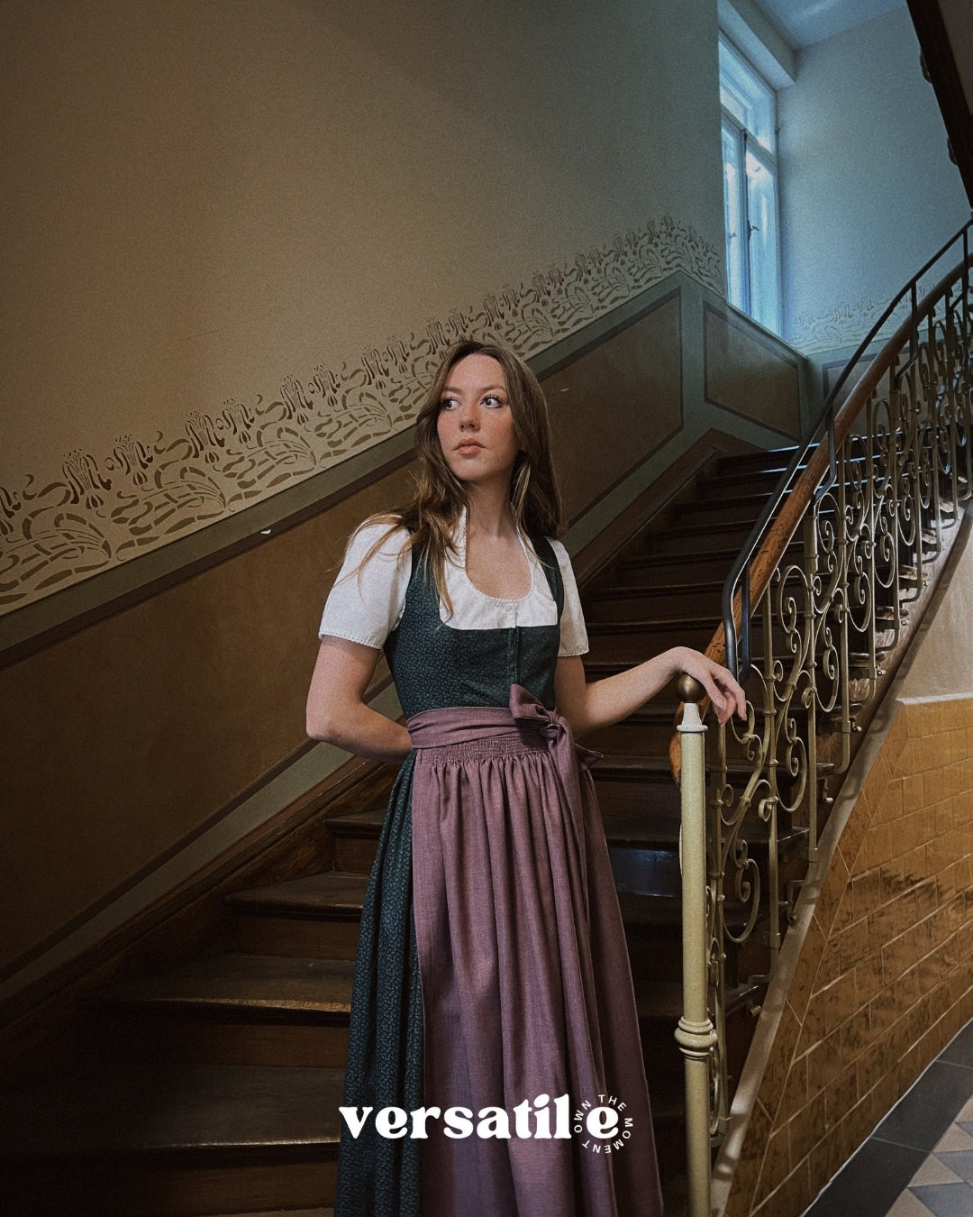 Handcrafted Dirndl Mia from Versatile Collection—romantic green floral design with plum apron, flattering silhouette, available for Oktoberfest dress hire in Munich.